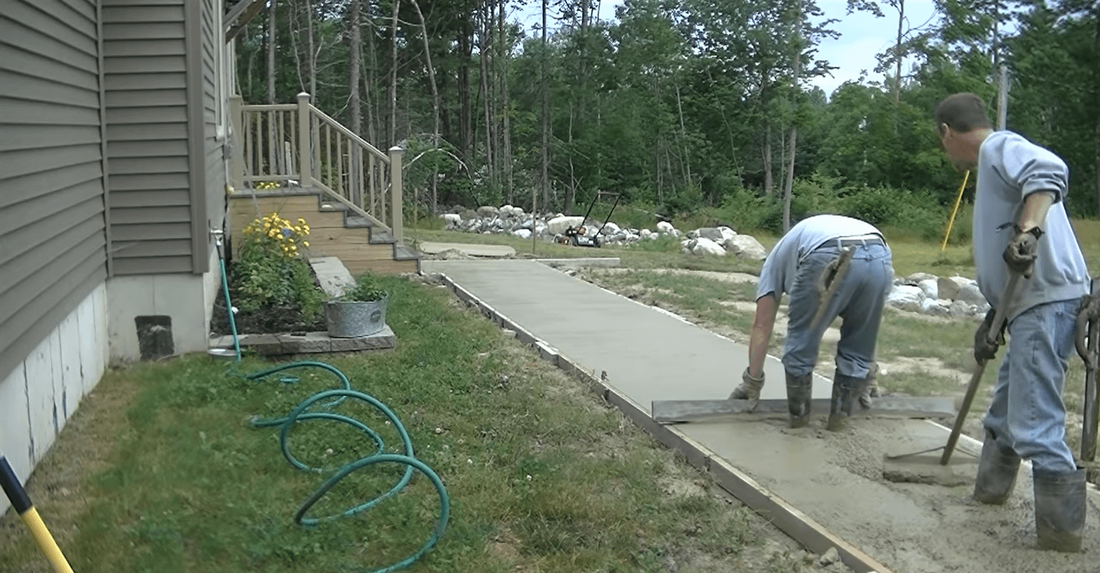 Finishing a new concrete walkway before applying a decorative stamp pattern